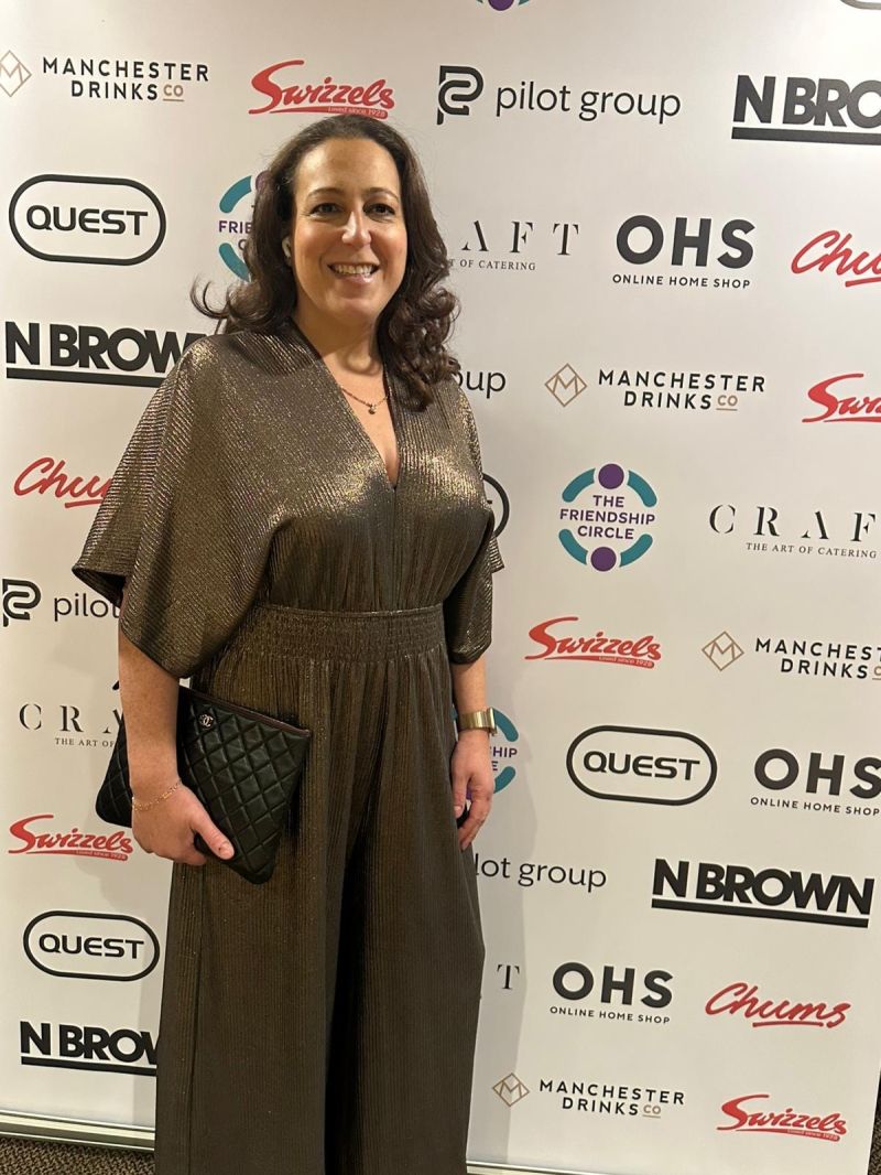 Hannah Cohen in a bronze jumpsuit at a Friendship Circle Manchester charity event